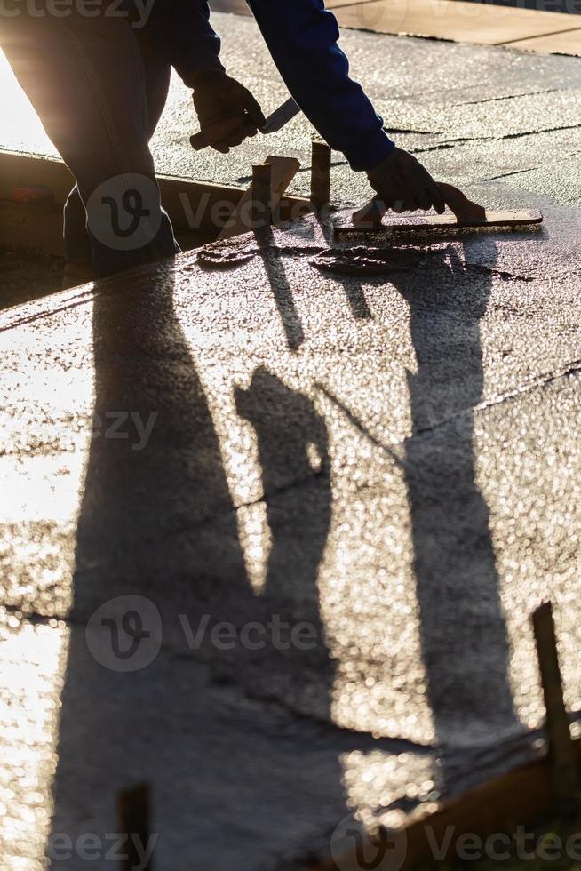 Construction Worker Smoothing Wet Cement With Trowel Tools photo