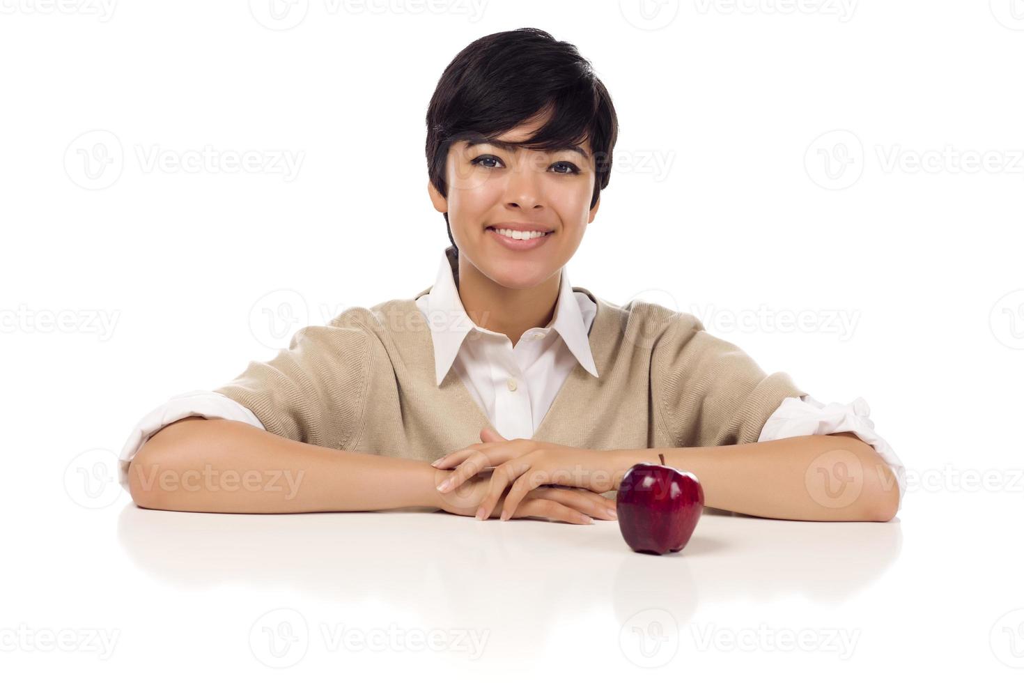 Hembra adulta joven de raza mixta sonriente sentada con Apple foto