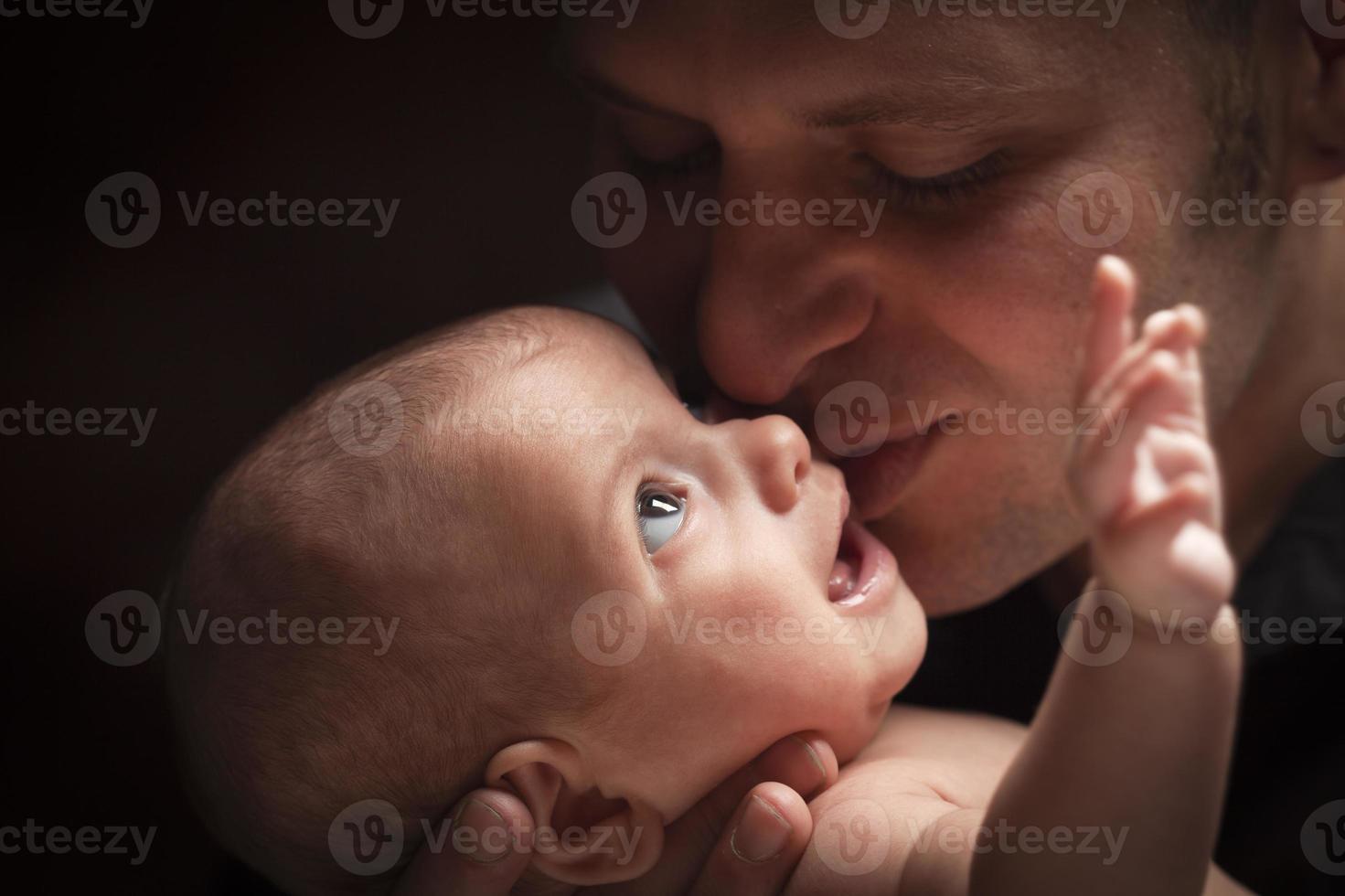 Young Father Holding His Mixed Race Newborn Baby photo