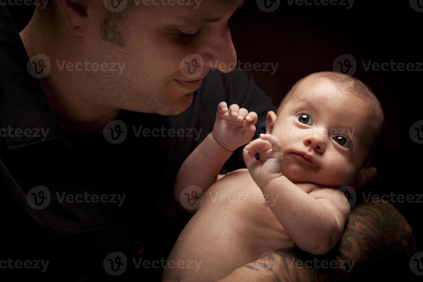 Young Father Holding His Mixed Race Newborn Baby photo