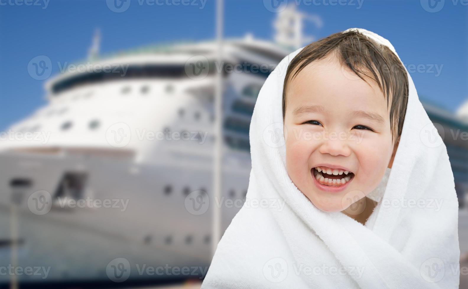 Happy Mixed Race Chinese and Caucasian Boy Near Cruise Ship Wrapped In A Towel photo