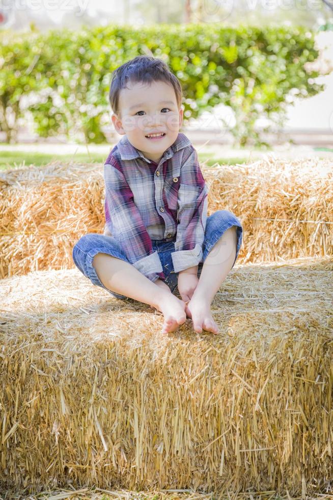 Cute Young Mixed Race Boy Having Fun on Hay Bale photo