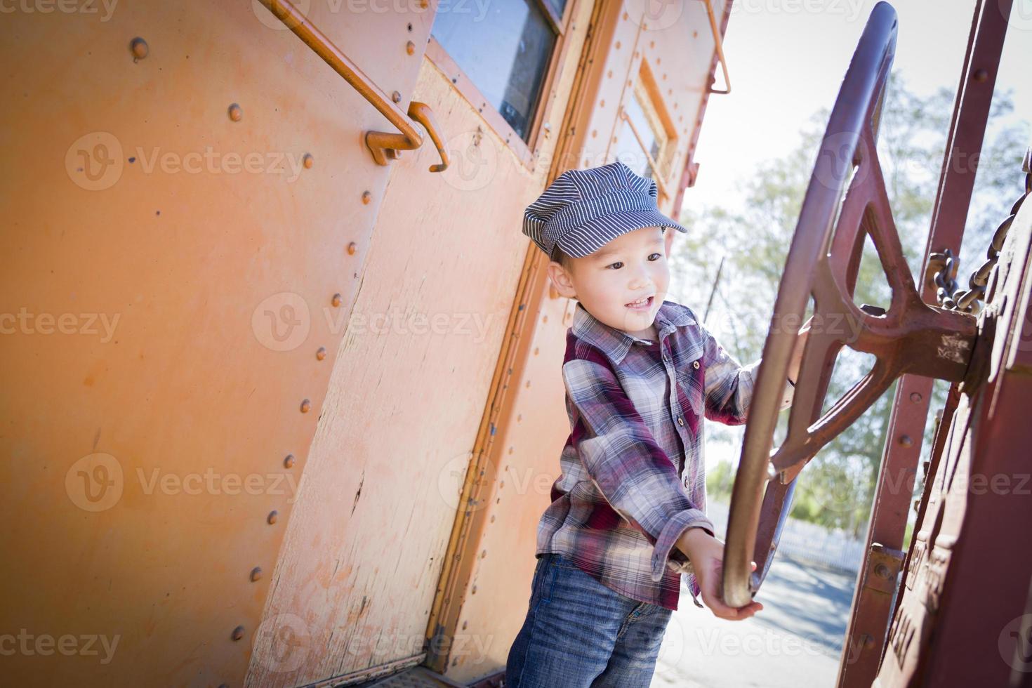 Cute Young Mixed Race Boy Having Fun on Railroad Car photo