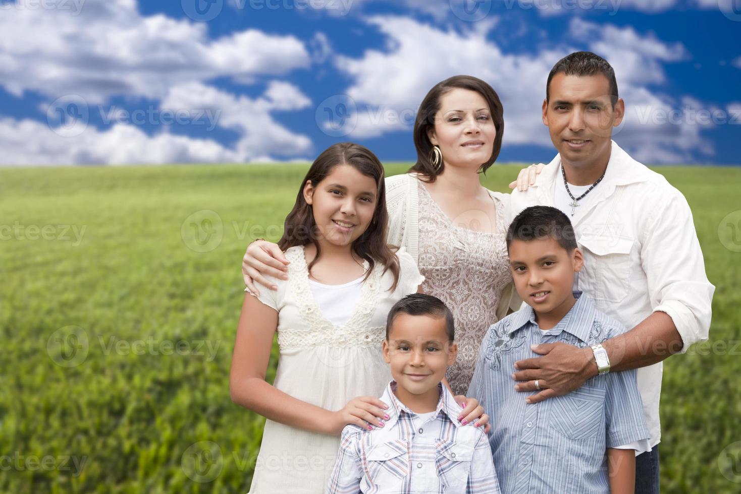 retrato de familia hispana de pie en el campo de hierba foto