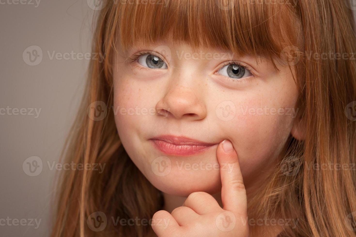 Fun Portrait of an Adorable Red Haired Girl on Grey photo