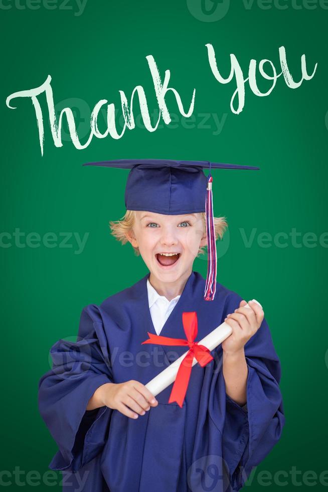 Young Caucasian Boy In Graduation Cap and Gown Against Green Chalkboard Background With Thank You photo