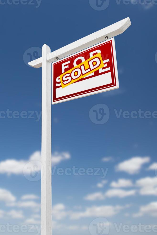 Right Facing Sold For Sale Real Estate Sign on a Blue Sky with Clouds. photo