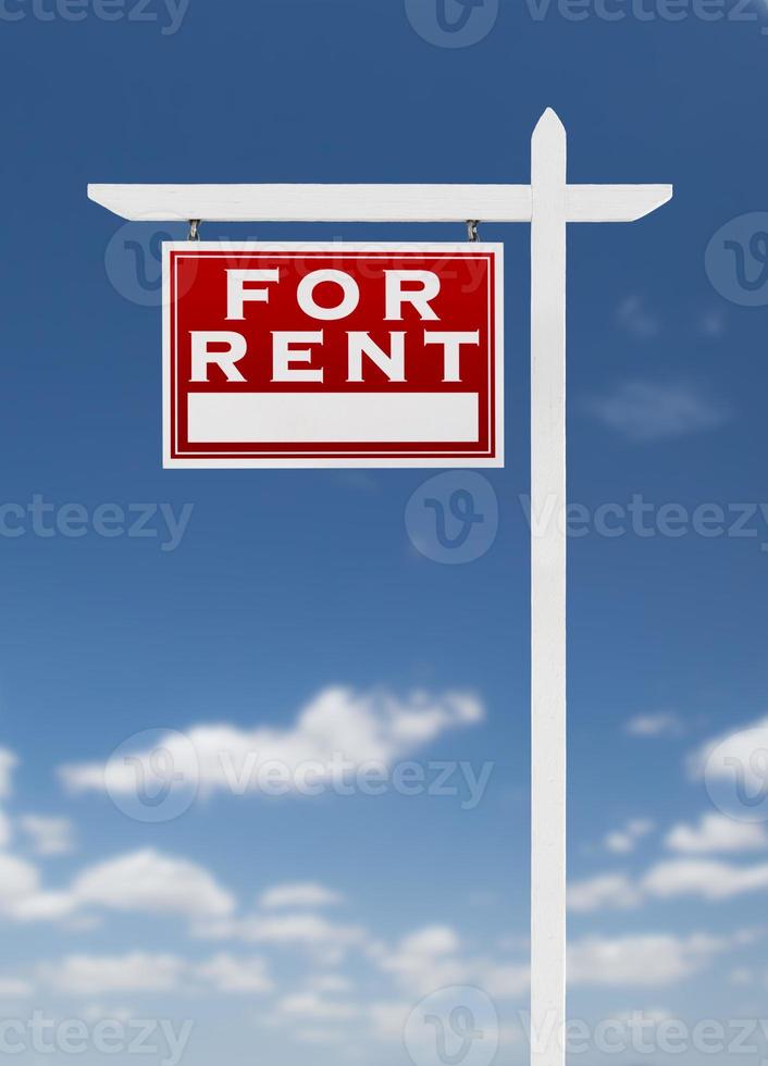 Left Facing For Rent Real Estate Sign on a Blue Sky with Clouds. photo