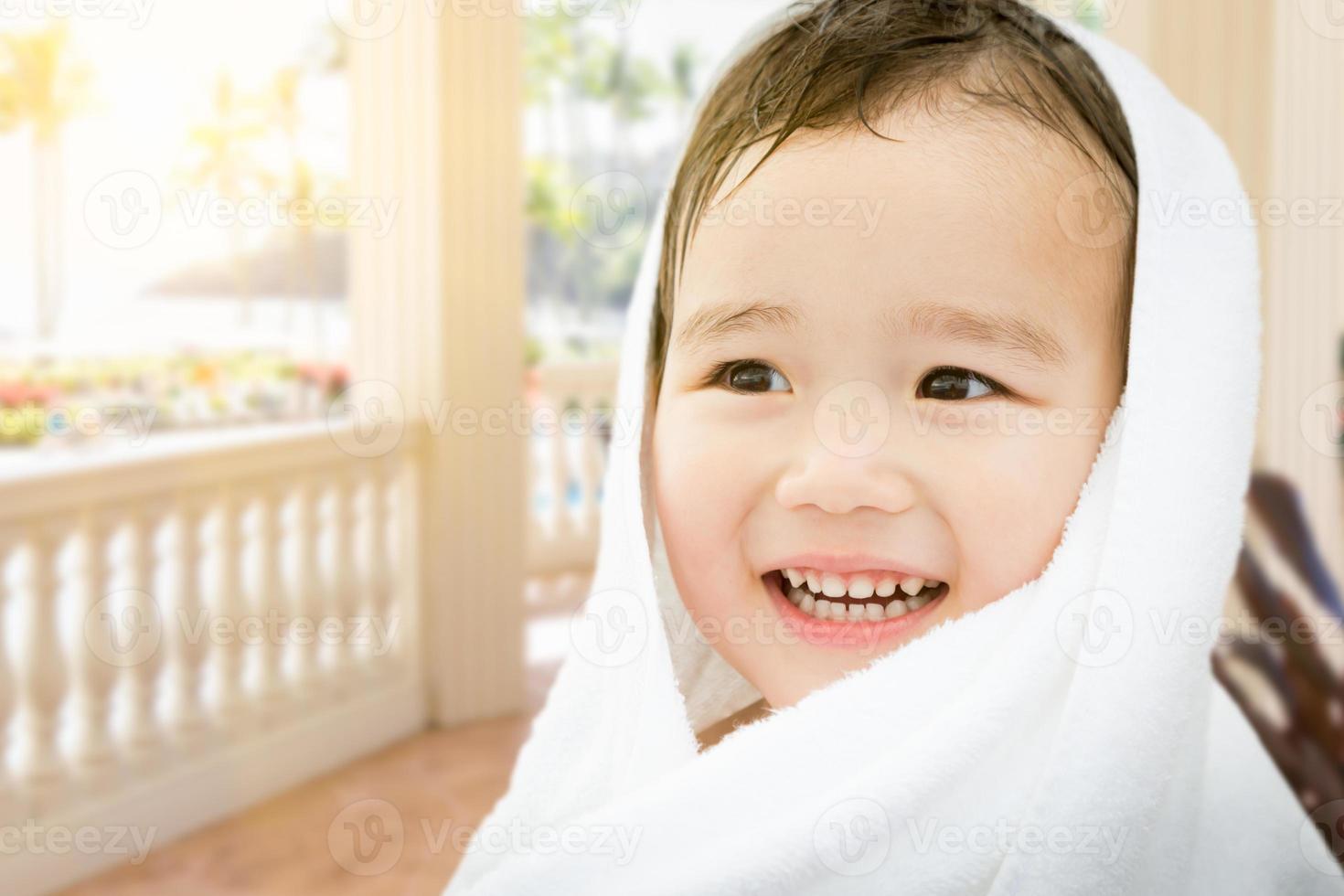 Happy Cute Mixed Race Chinese and Caucasian Boy On Tropical Patio Wrapped In A Towel photo