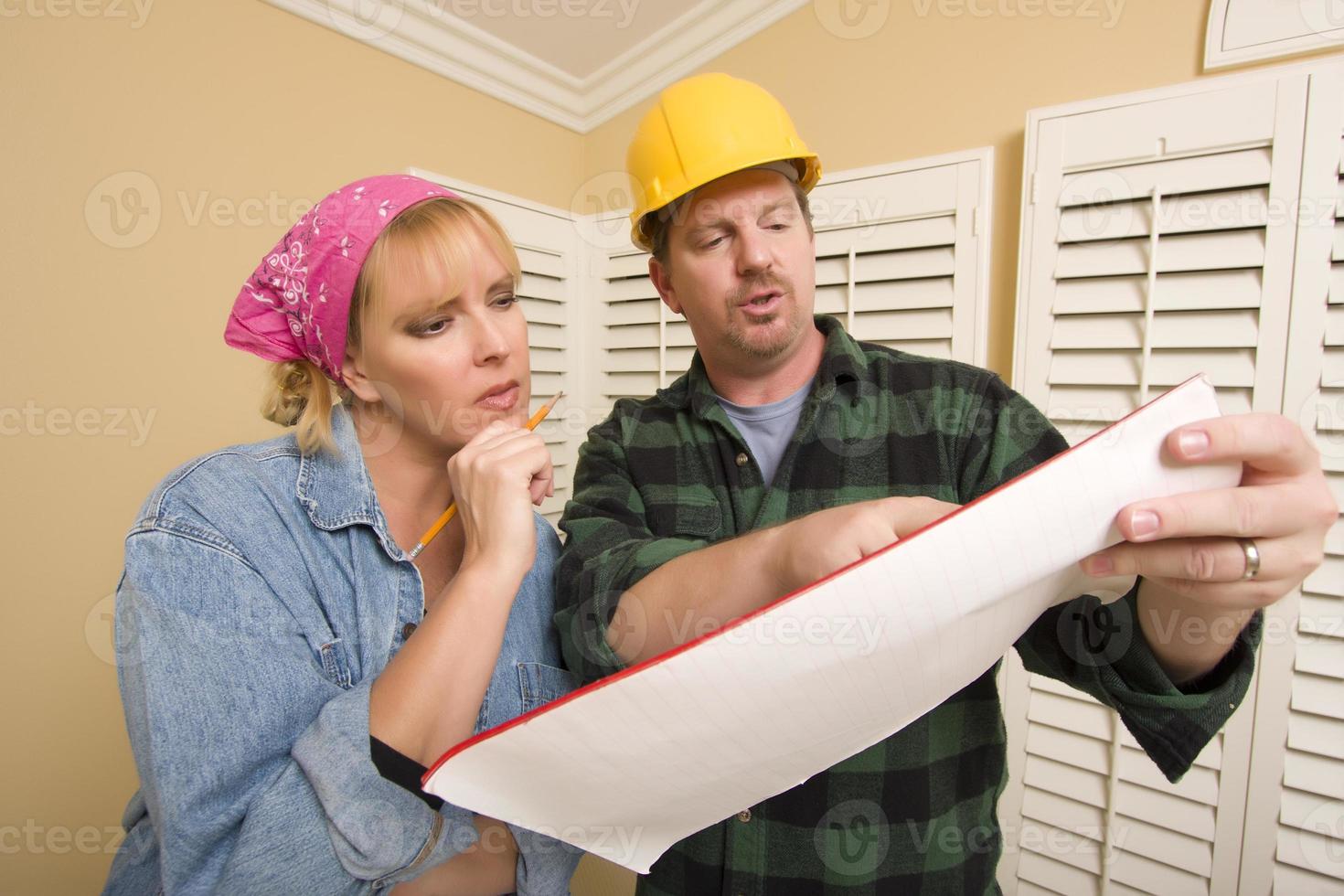 Contractor in Hard Hat Discussing Plans with Woman photo