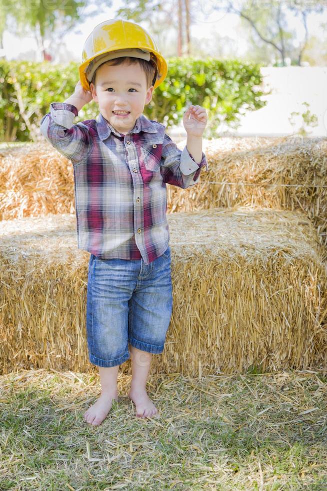 Young Mixed Race Boy Laughing with Hard Hat Outside photo