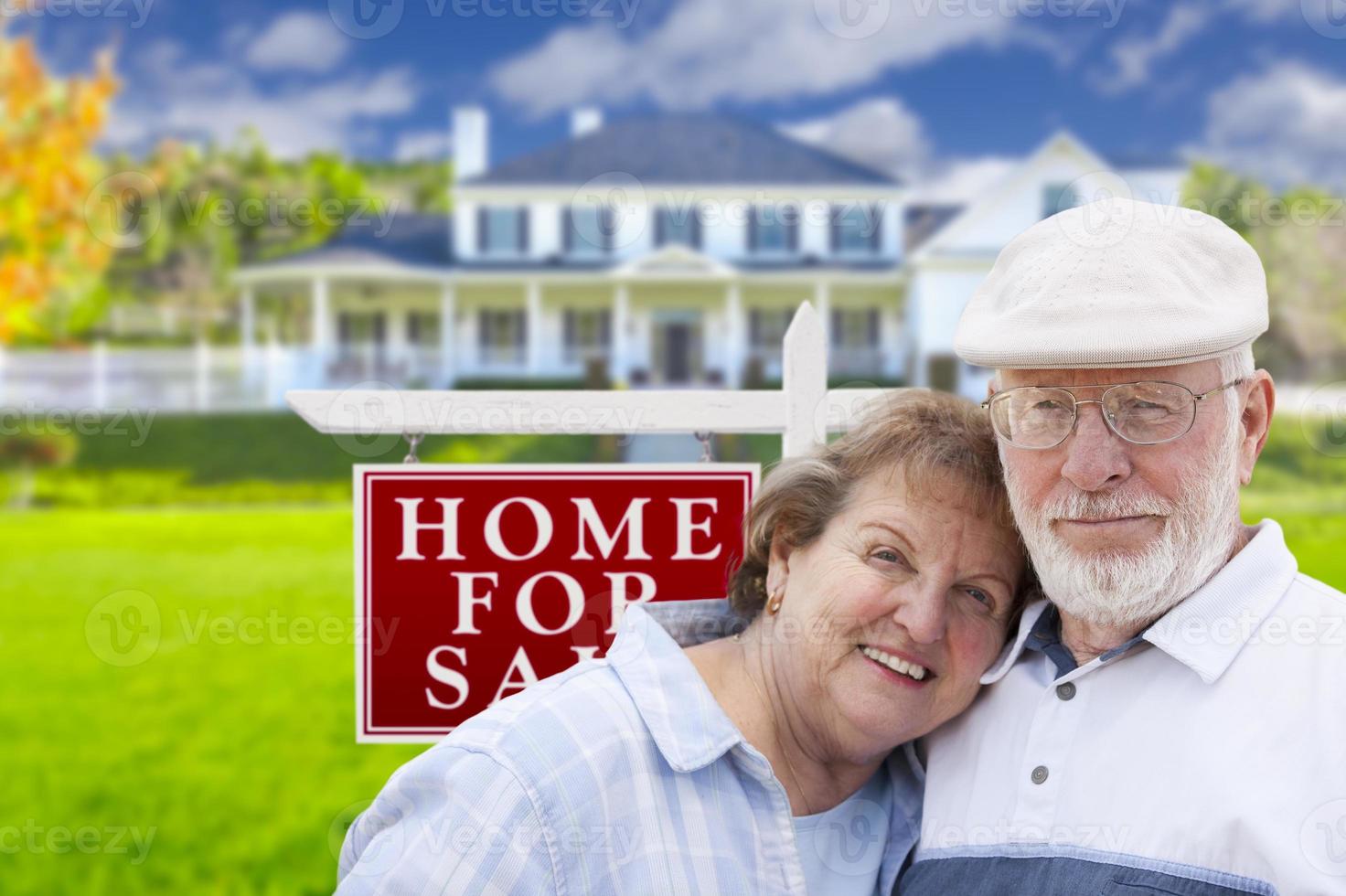 Happy Senior Couple Front of For Sale Sign and House photo