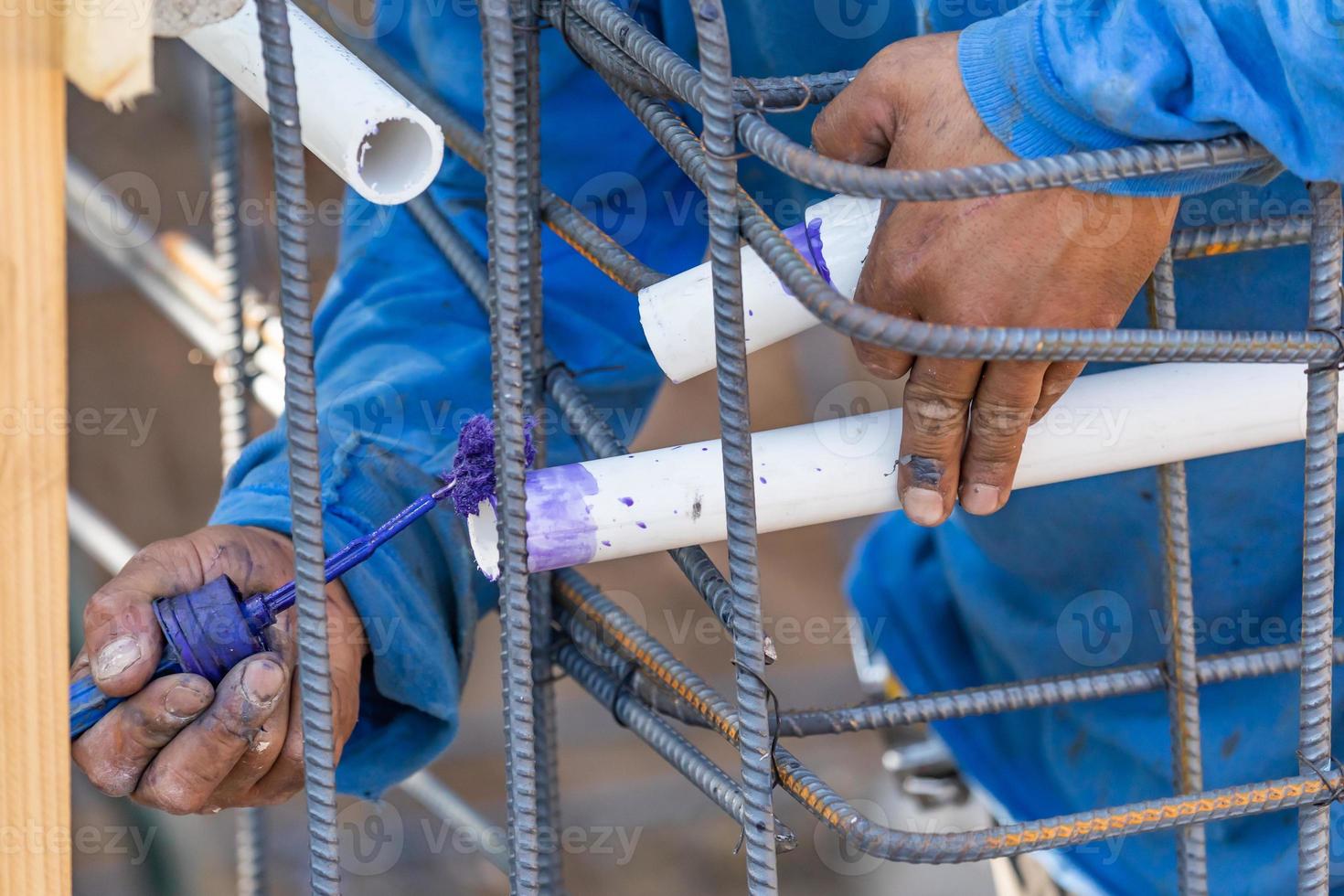 Plumber Applying Pipe Cleaner, Primer and Glue to PVC Pipe At Construction Site 16431496 Stock