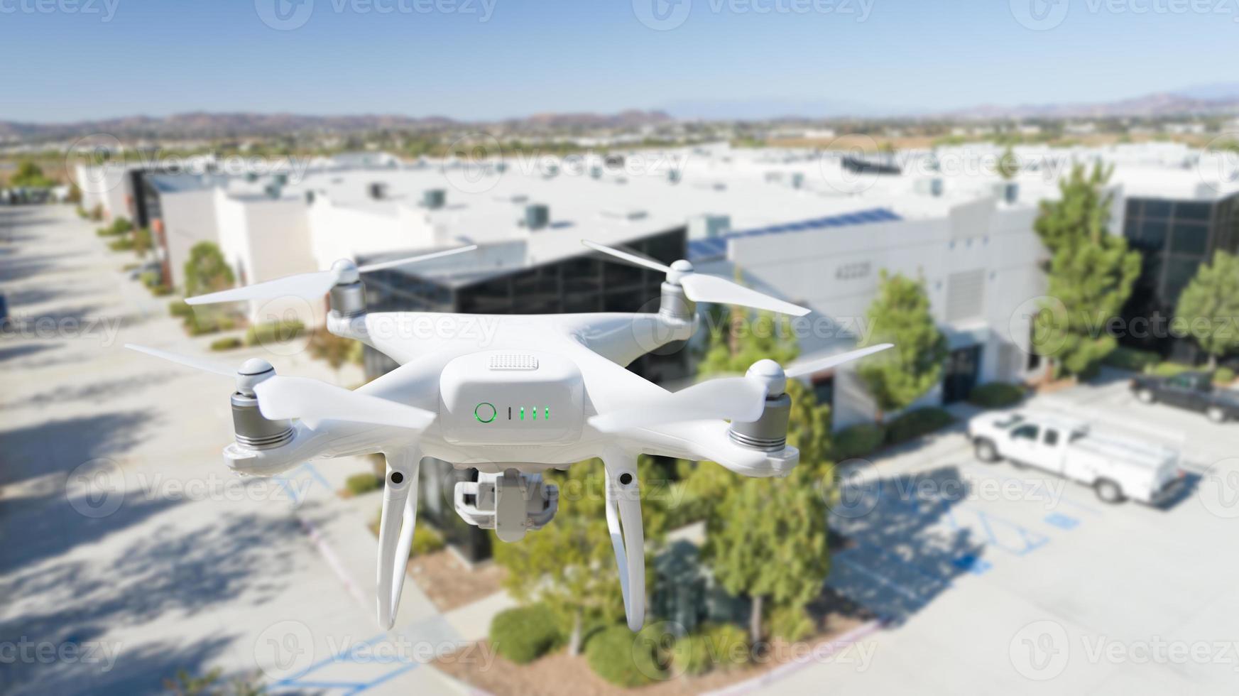 Unmanned Aircraft System Quadcopter Drone In The Air Near Corporate Industrial Building photo