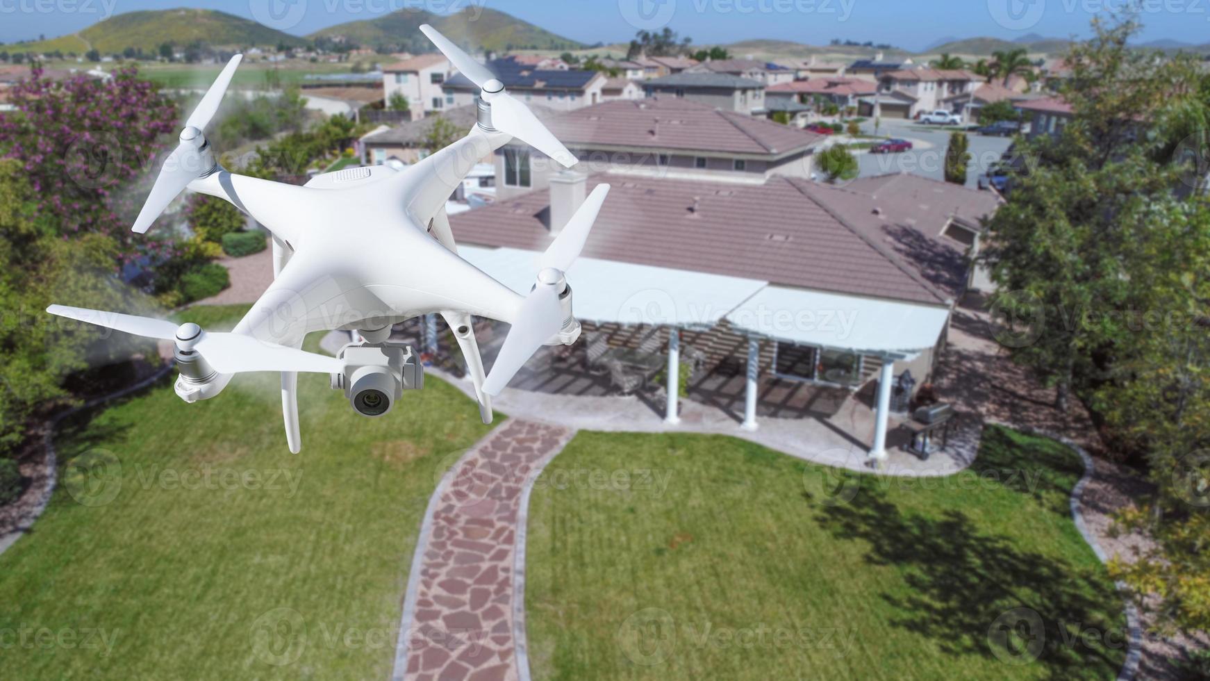 Unmanned Aircraft System Quadcopter Drone In The Air Over House. photo