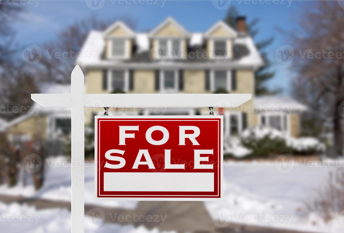 Home For Sale Real Estate Sign in Front of New Snow Covered House photo