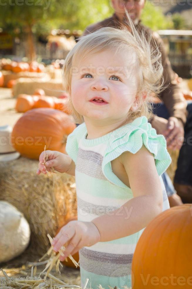 adorable niña divirtiéndose en el huerto de calabazas foto