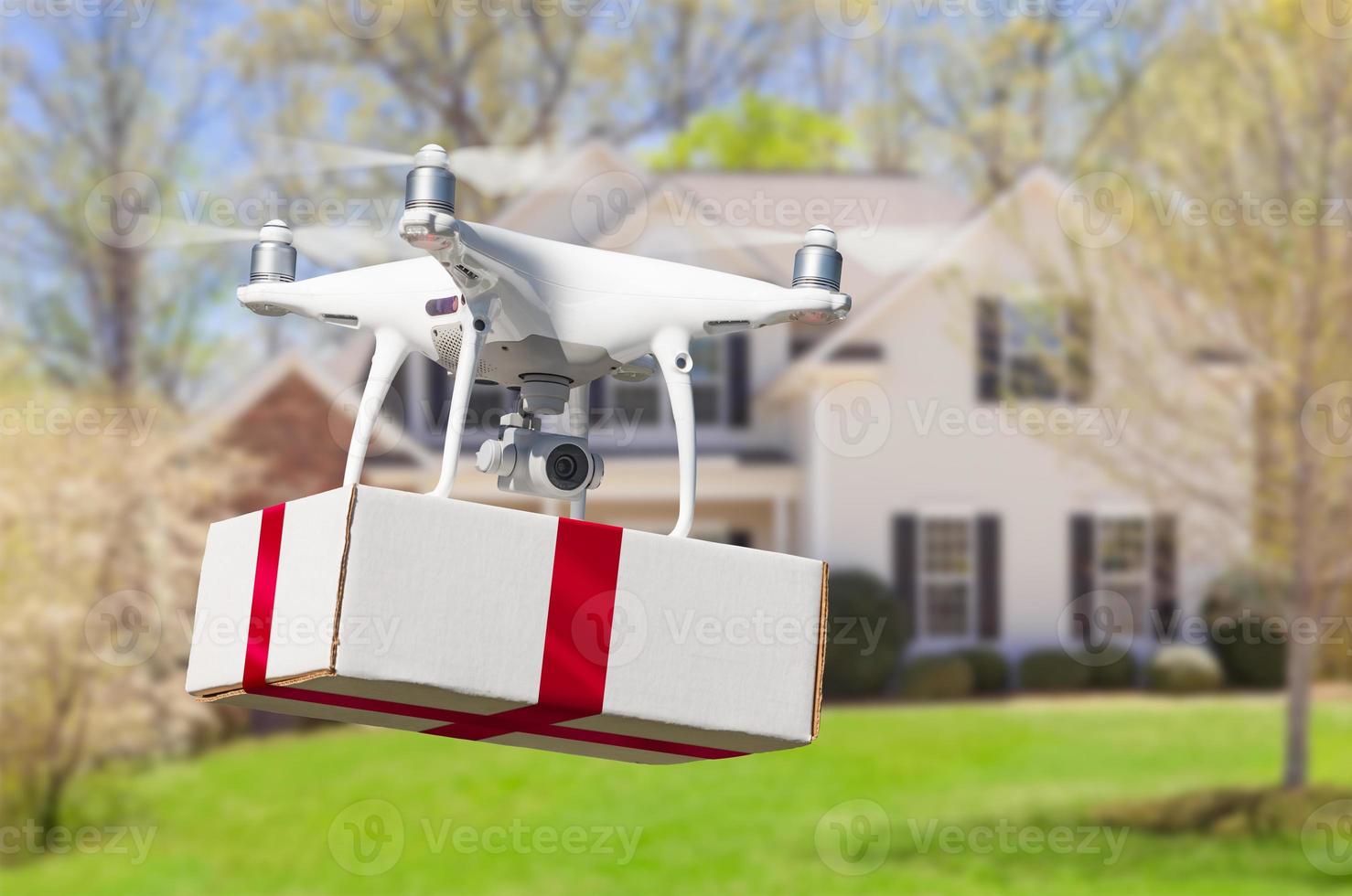 Unmanned Aircraft System UAV Quadcopter Drone Delivering Box With Red Ribbon To Home photo