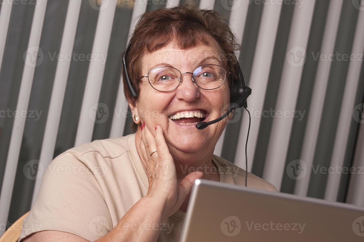 Smiling Senior Adult Woman with Telephone Headset and Monitor photo