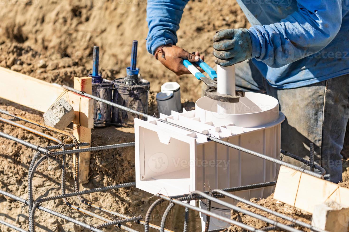 fontanero usando una llave para instalar tubería de pvc en el sitio de construcción foto