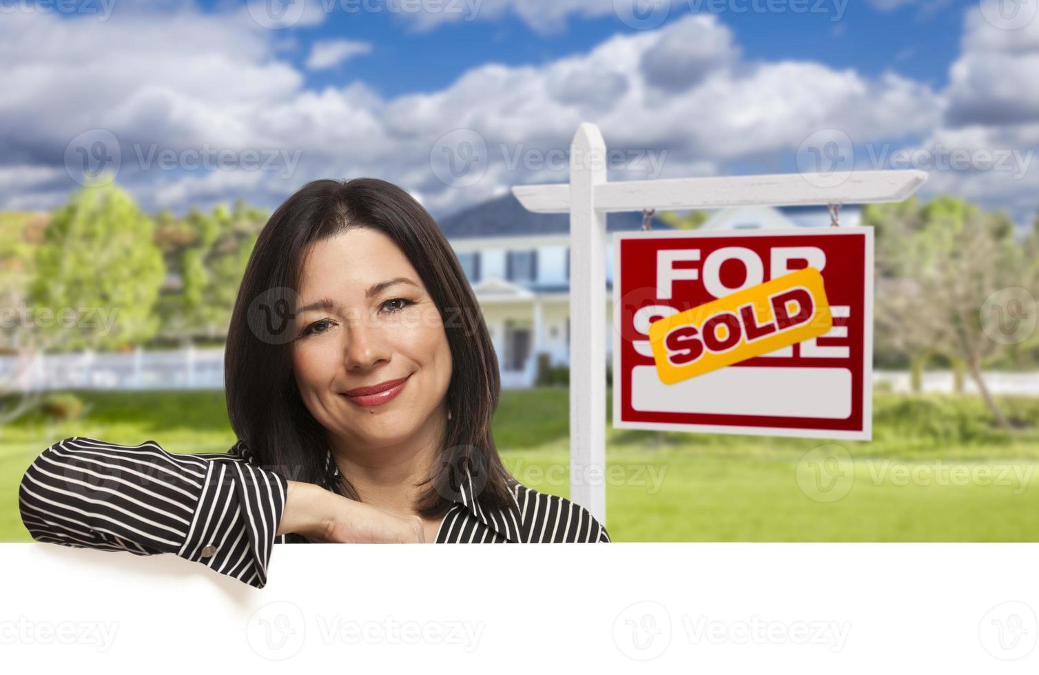Hispanic Woman in Front of Sold For Sale Sign, House photo