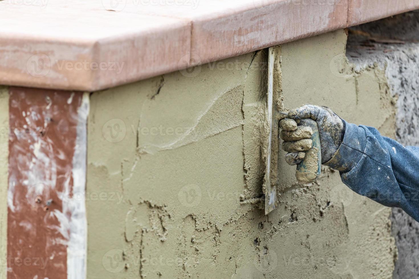 Tile Worker Applying Cement with Trowel at Pool Construction Site photo