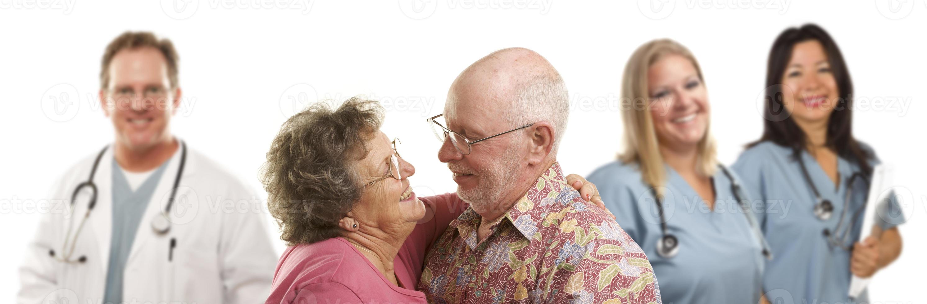 Senior Couple with Medical Doctors or Nurses Behind photo