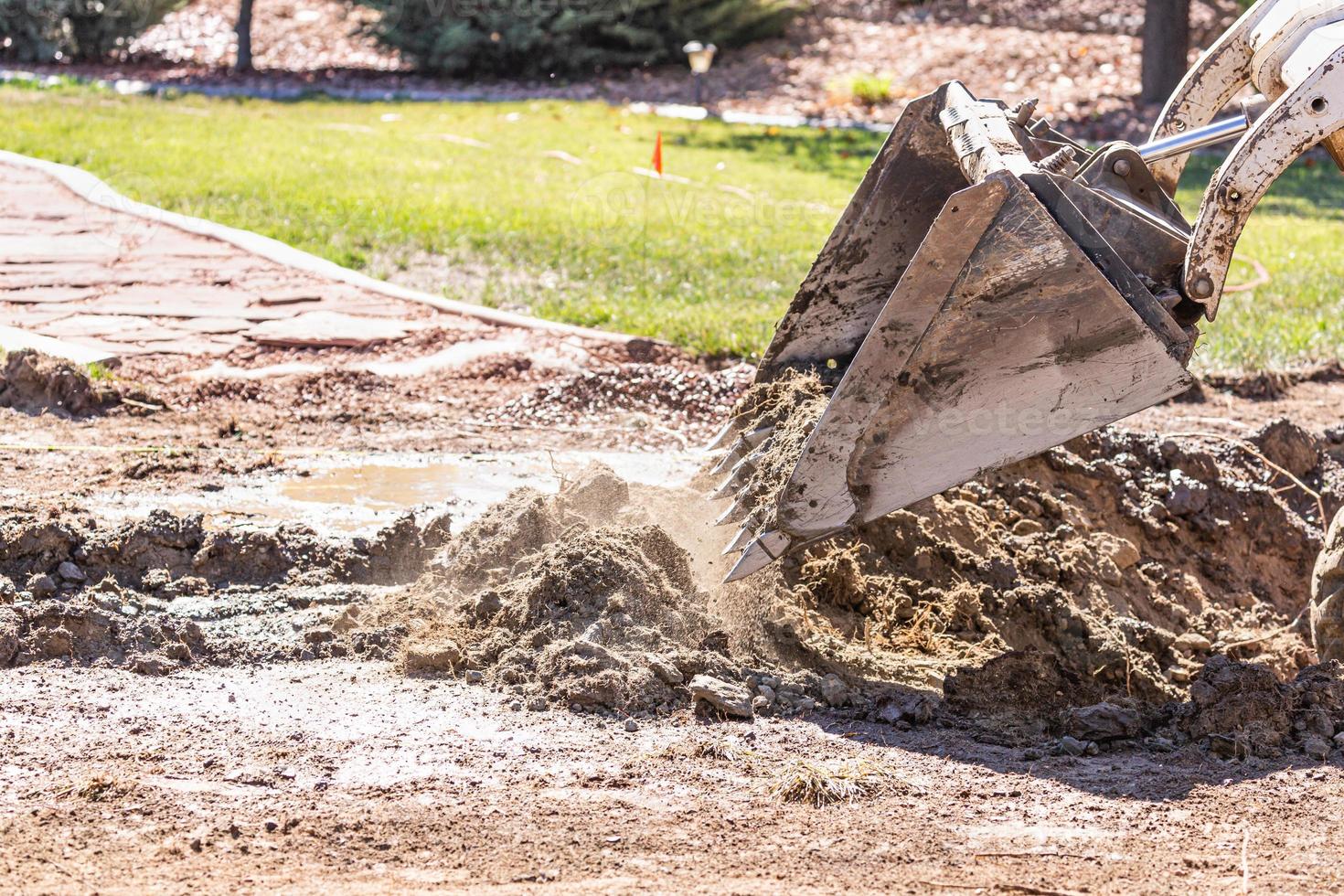 Small Bulldozer Digging In Yard For Pool Installation photo