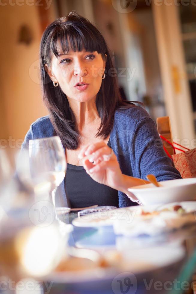 bonita mujer italiana disfruta de una comida y bebidas con amigos en un restaurante al aire libre foto