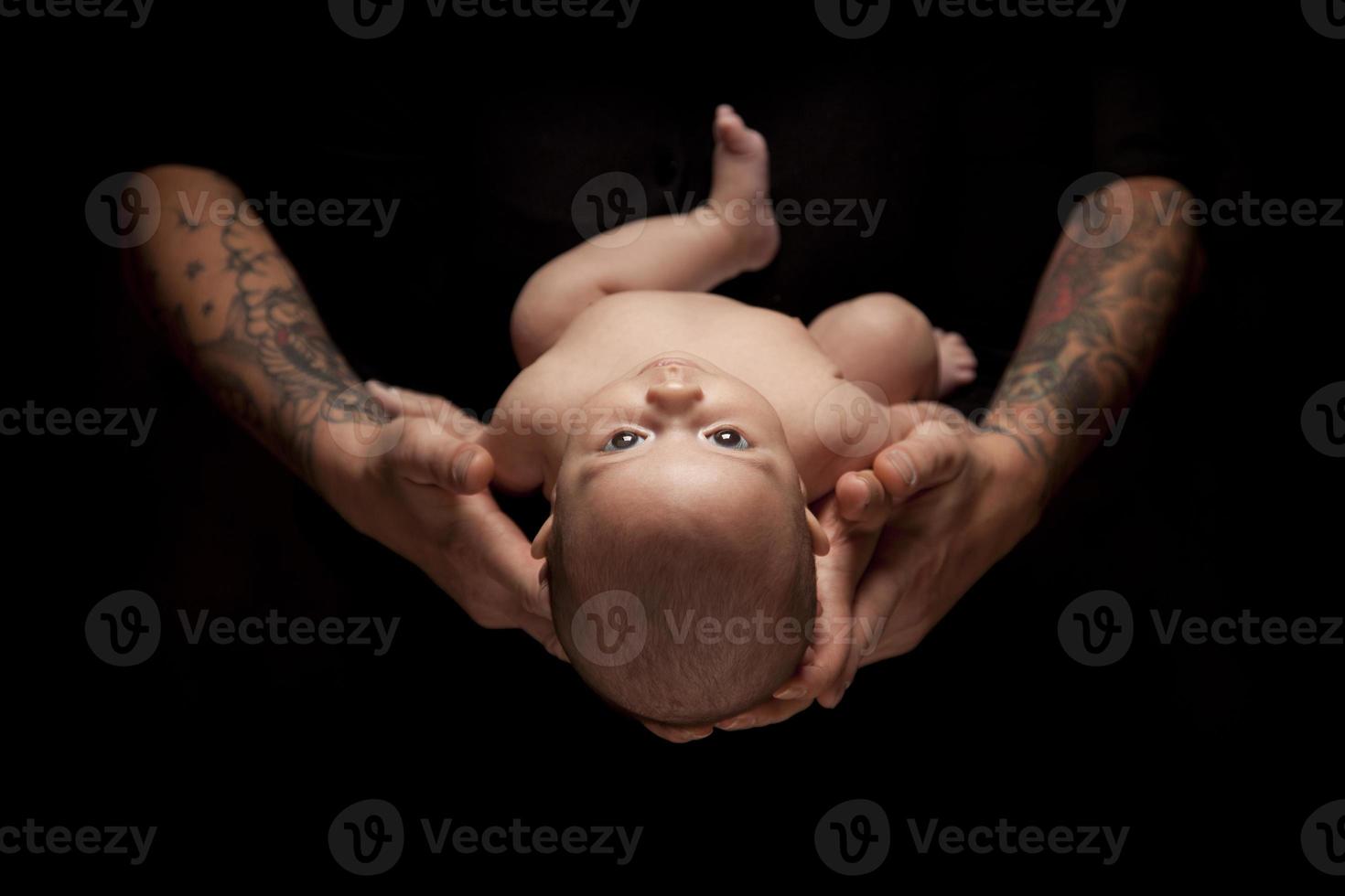 Hands of Father and Mother Hold Newborn Baby on Black photo