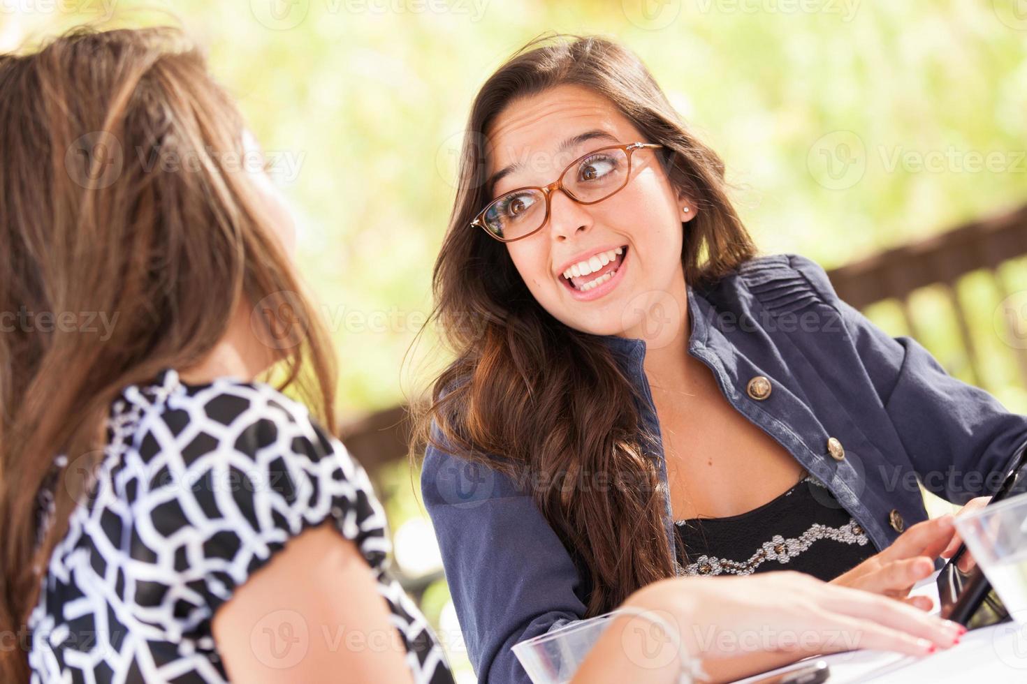 Expressive Young Adult Girlfriends Using Their Computer Electronics Outdoors photo