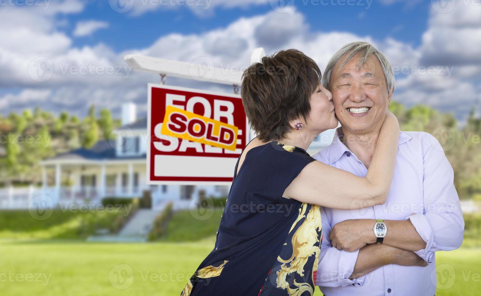 Affectionate Senior Chinese Couple In Front of House and Sign photo