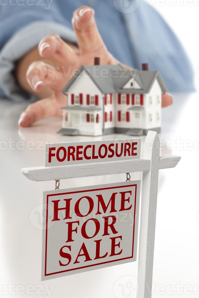 Foreclosure Sign in Front of Woman Reaching for House photo