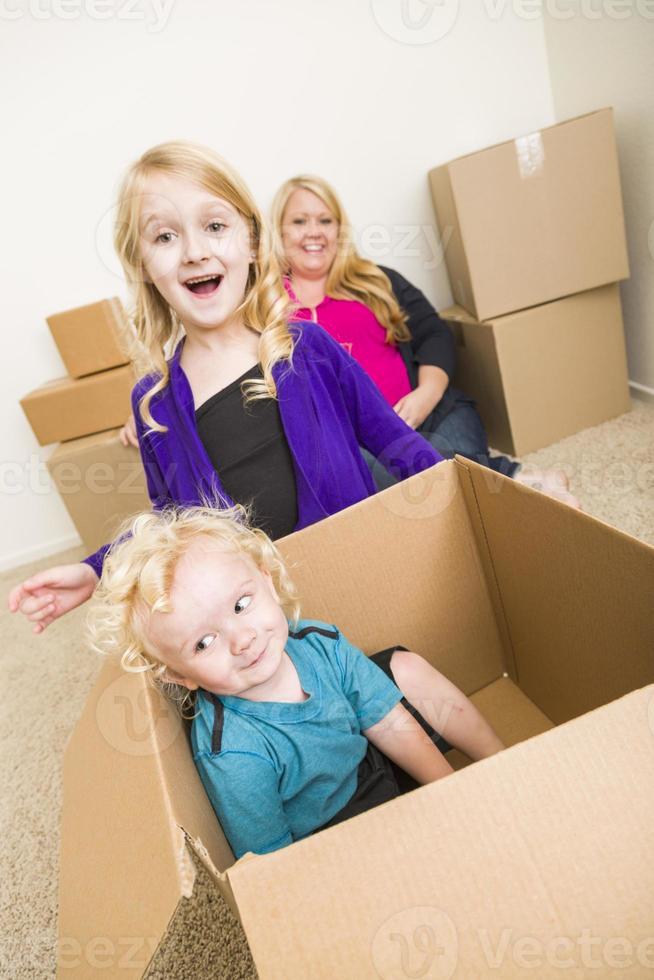 Young Family In Empty Room Playing With Moving Boxes photo