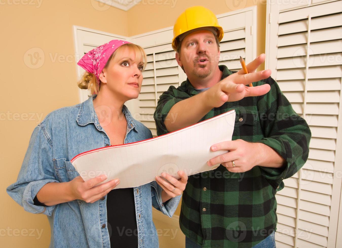 Contractor in Hard Hat Discussing Plans with Woman photo