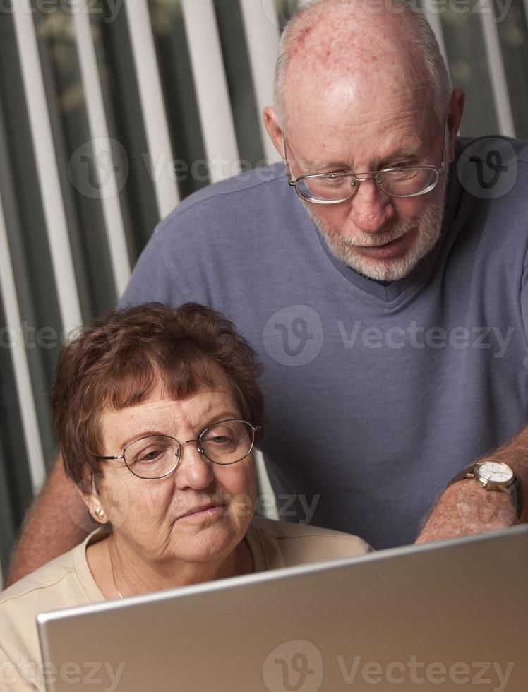 Smiling Senior Adult Couple Having Fun on the Computer photo