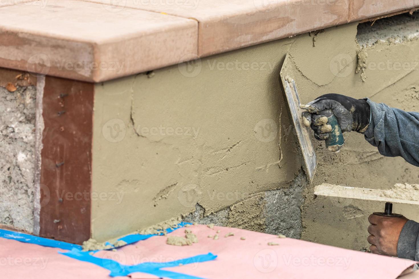 Tile Worker Applying Cement with Trowel at Pool Construction Site photo