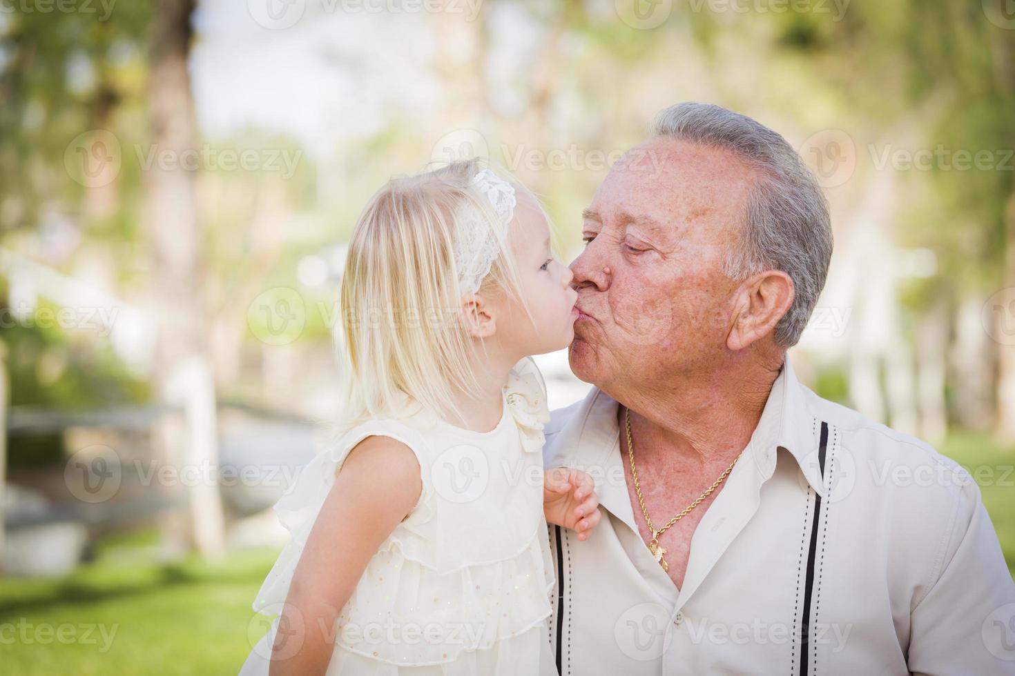 Grandfather and Granddaughter Kissing At The Park photo