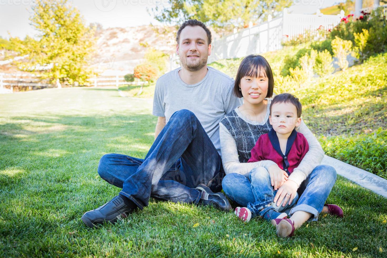 Happy Mixed Race Family Having Fun Outside on the Grass photo