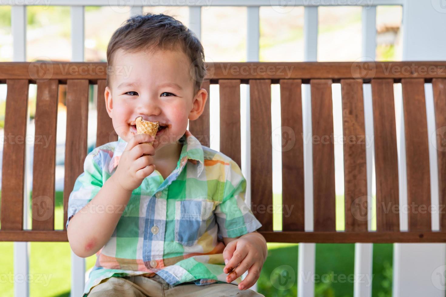 Young Mixed Race Chinese and Caucasian Boy Enjoying His Ice Cream Cone photo