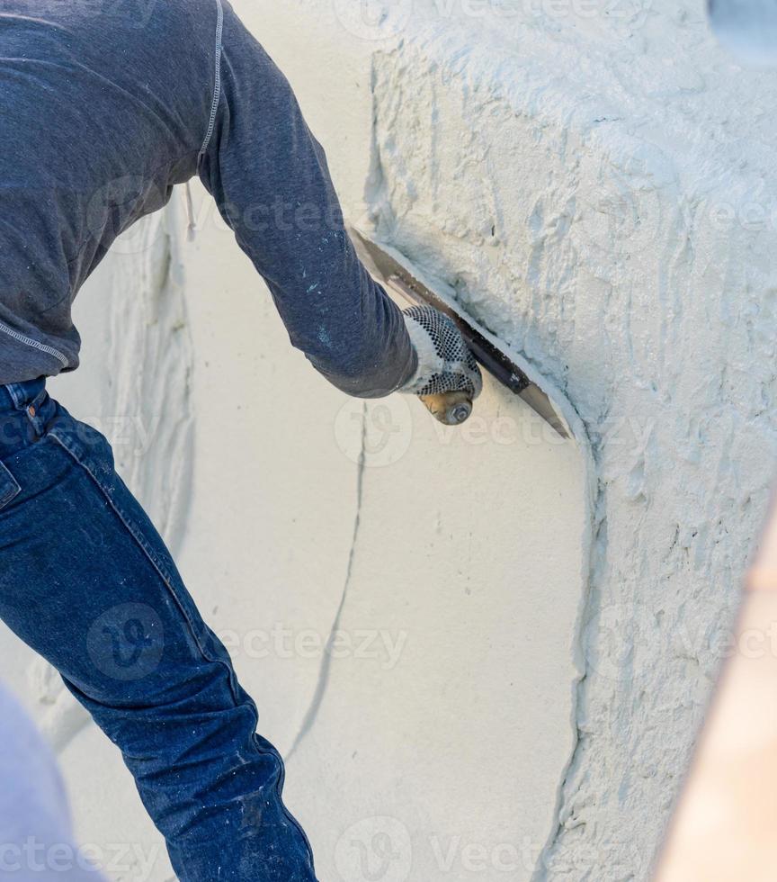 Worker Smoothing Wet Pool Plaster With Trowel photo
