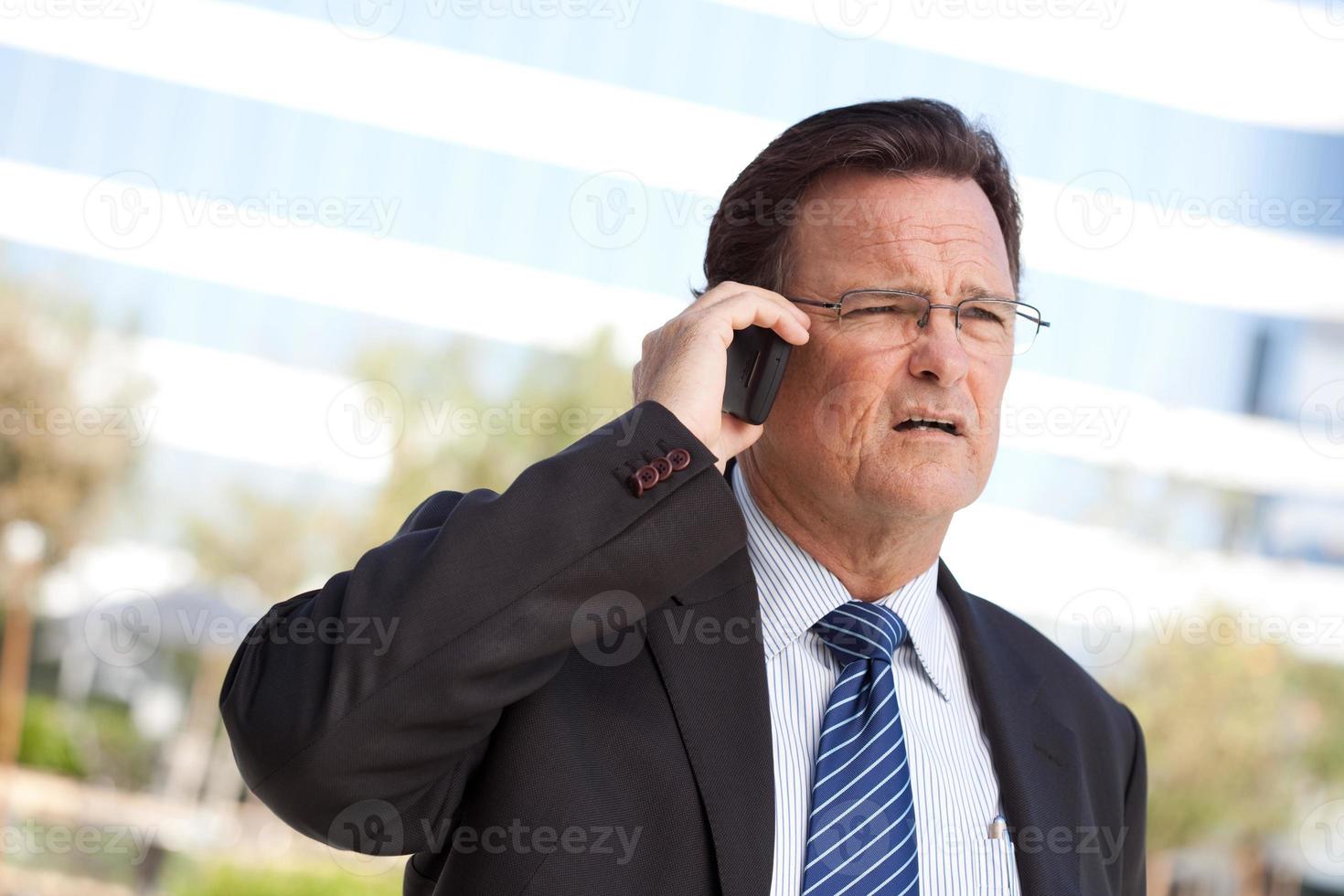 Concerned Businessman Talks on His Cell Phone photo