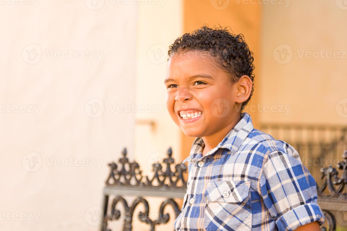 Guapo chico afroamericano y mexicano sentado en un banco del parque foto