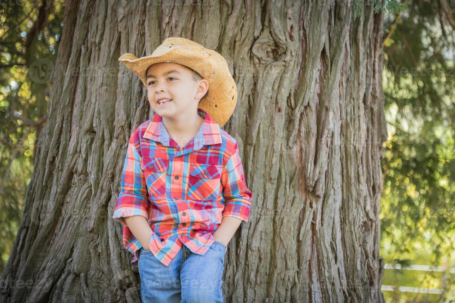 Mixed Race Young Boy Wearing Cowboy Hat Standing Outdoors. photo