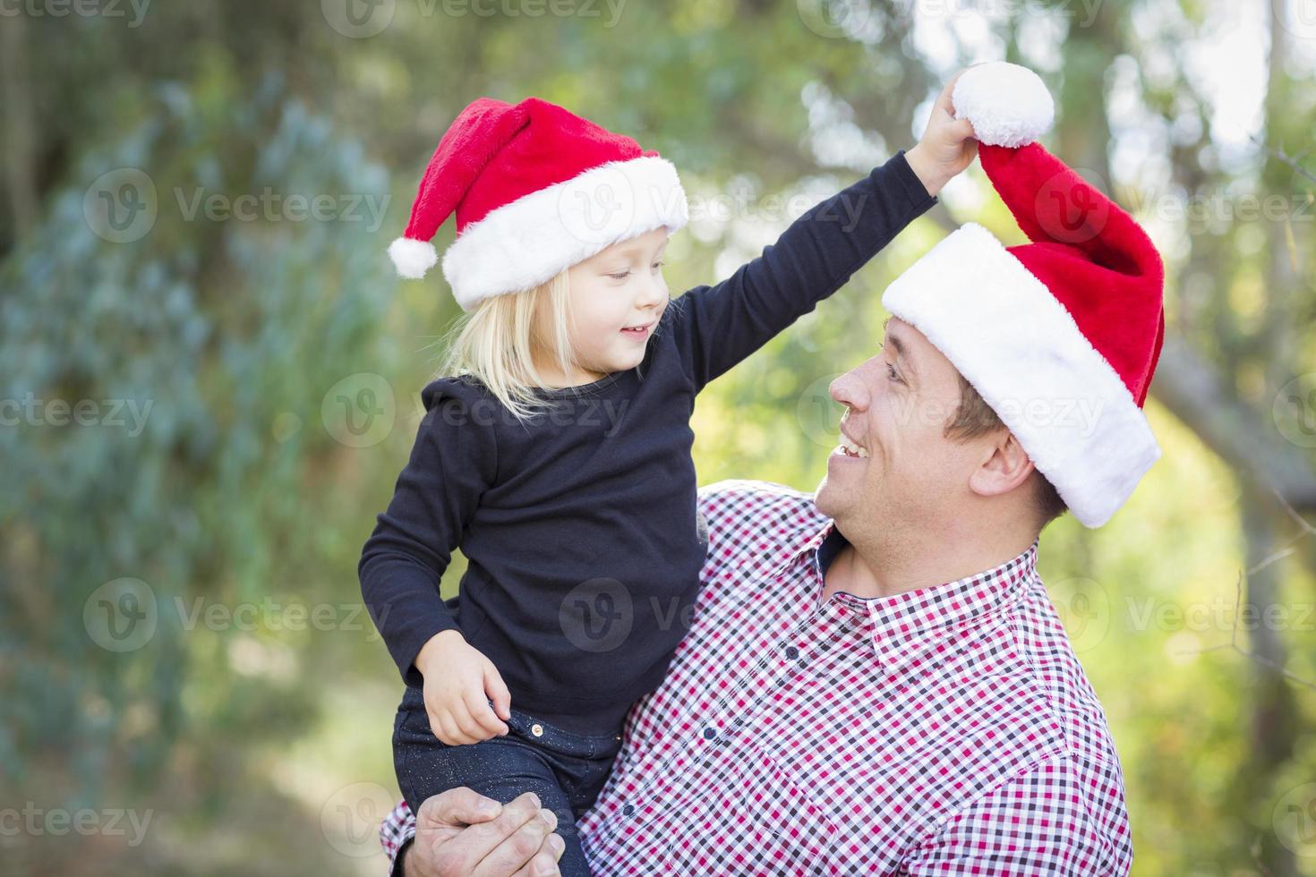 Father and Daughter Having Fun Wearing Santa Hats photo