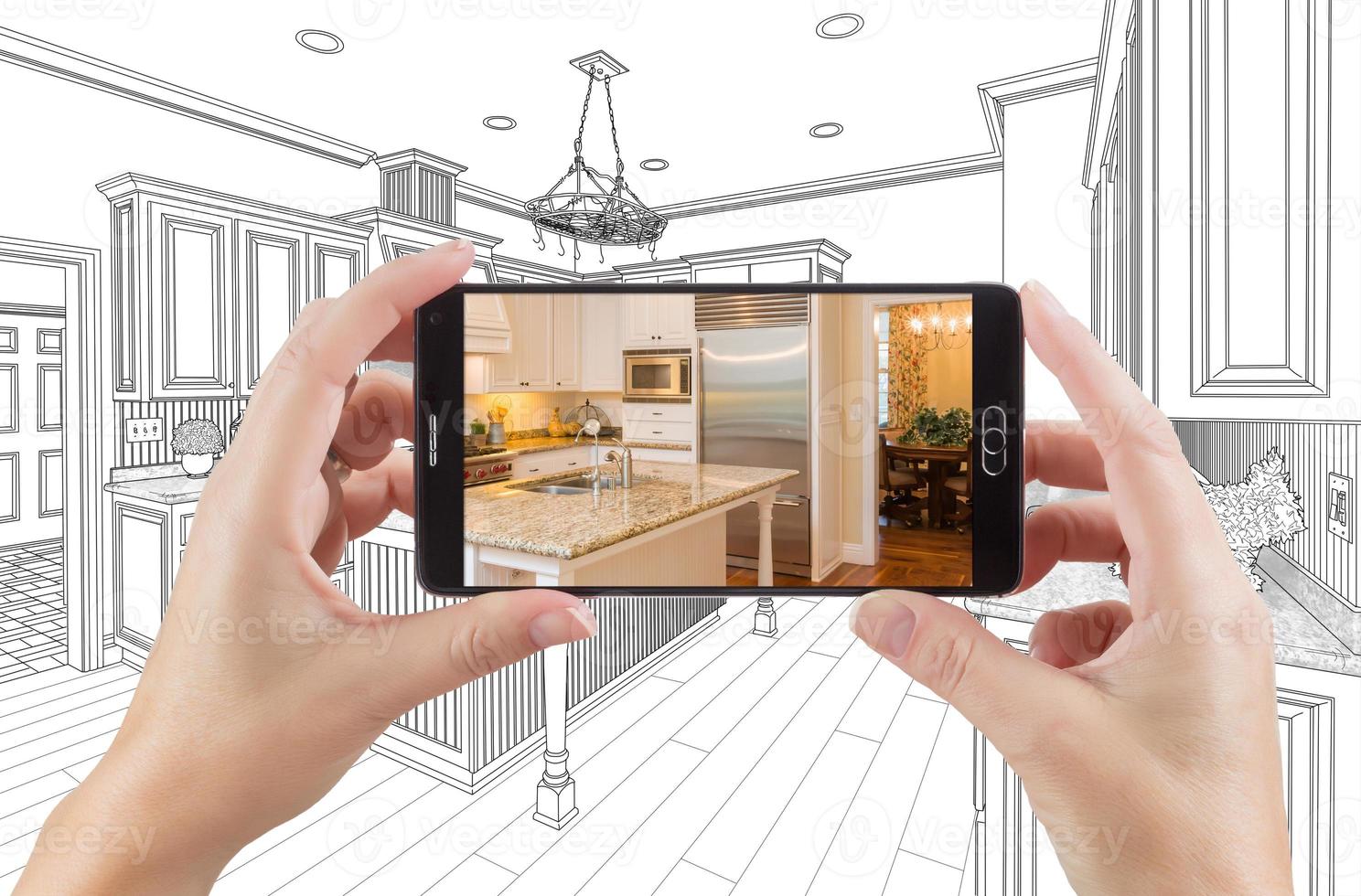 Hands Holding Smart Phone Displaying Photo of Kitchen Drawing Behind