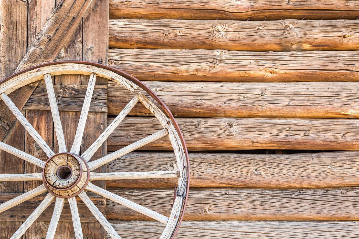 Abstract of Vintage Antique Log Cabin Wall and Wagon Wheel. photo