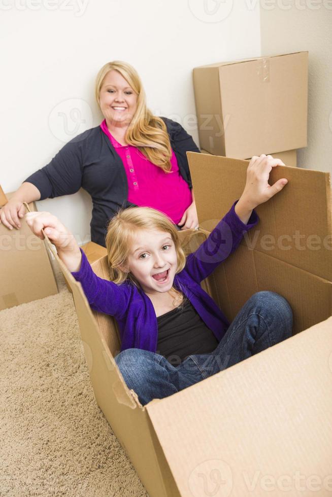 Young Family In Empty Room Playing With Moving Boxes photo