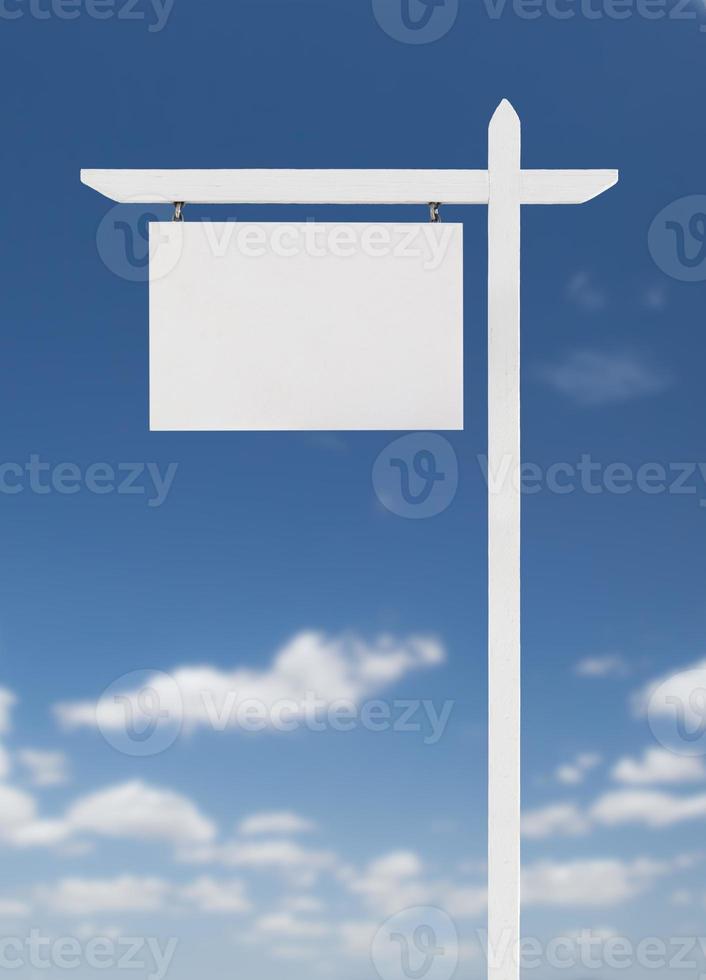 Blank Real Estate Sign Over A Blue Sky with Clouds. photo
