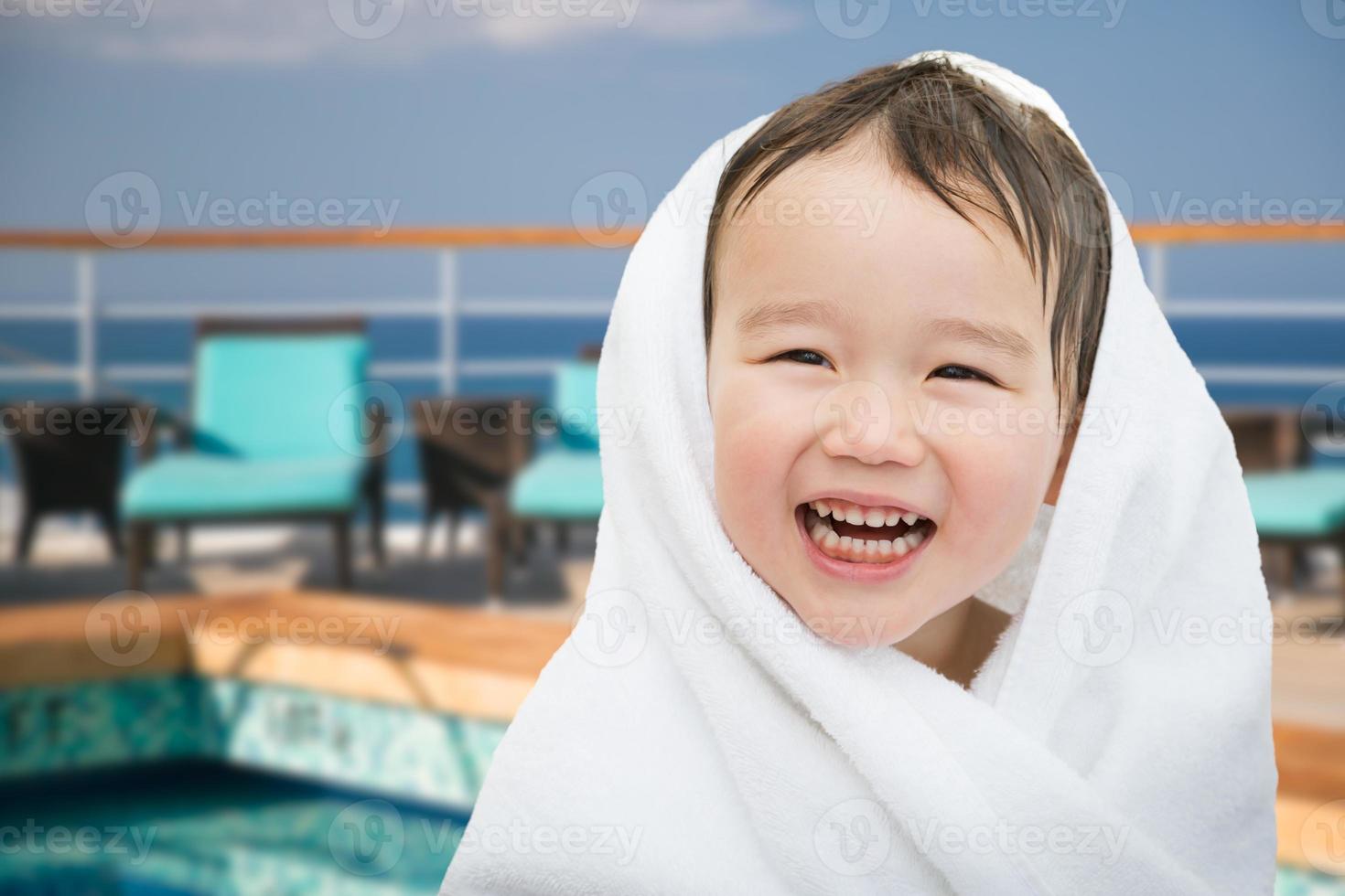 Happy Cute Mixed Race Chinese and Caucasian Boy On Cruise Ship Wrapped In A Towel photo